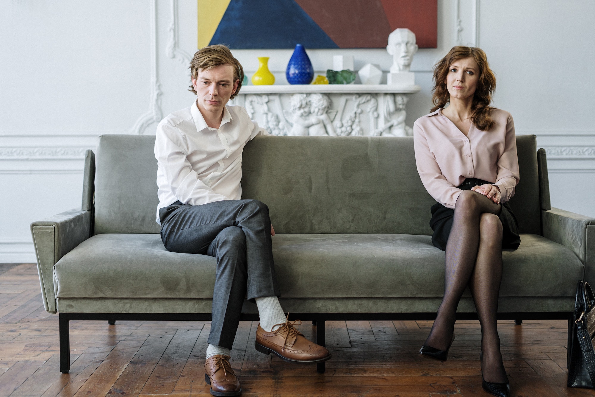 Man and woman sitting on opposite sides of a couch