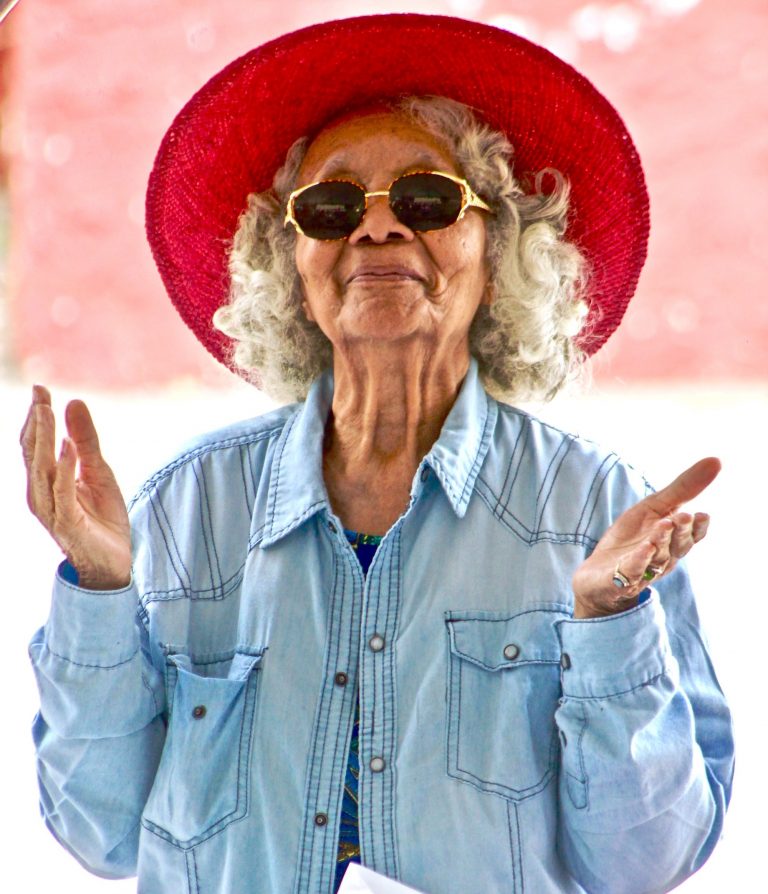happy older woman wearing a red hat