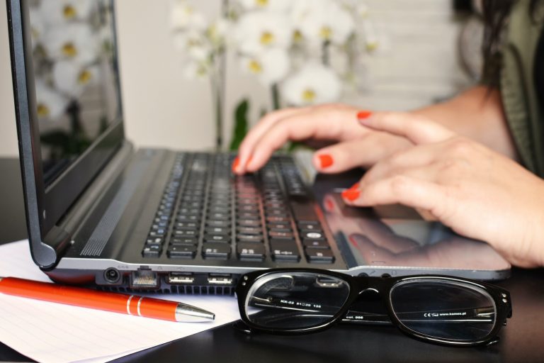 Woman on laptop with pen