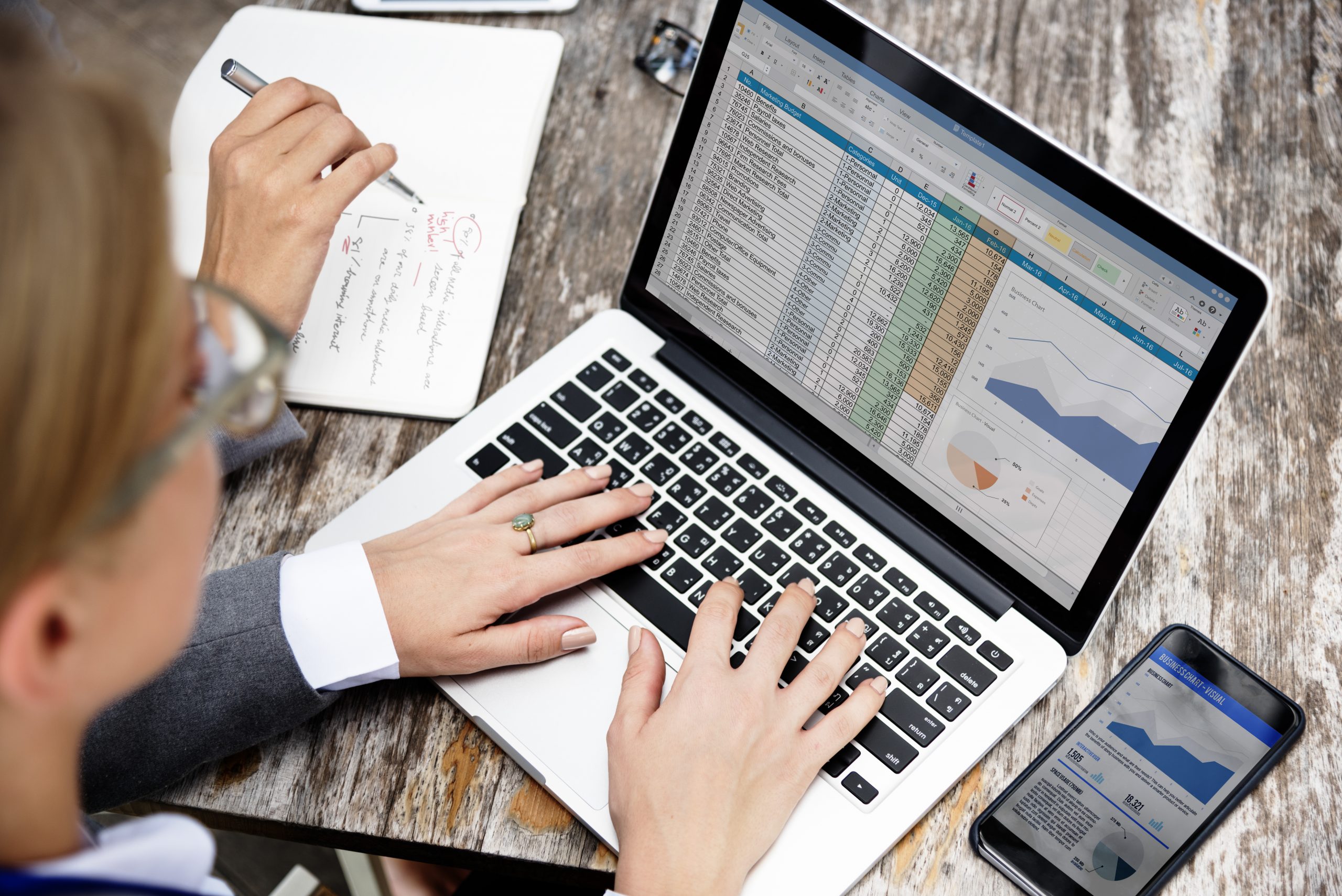 Spreadsheet on laptop and graph on phone