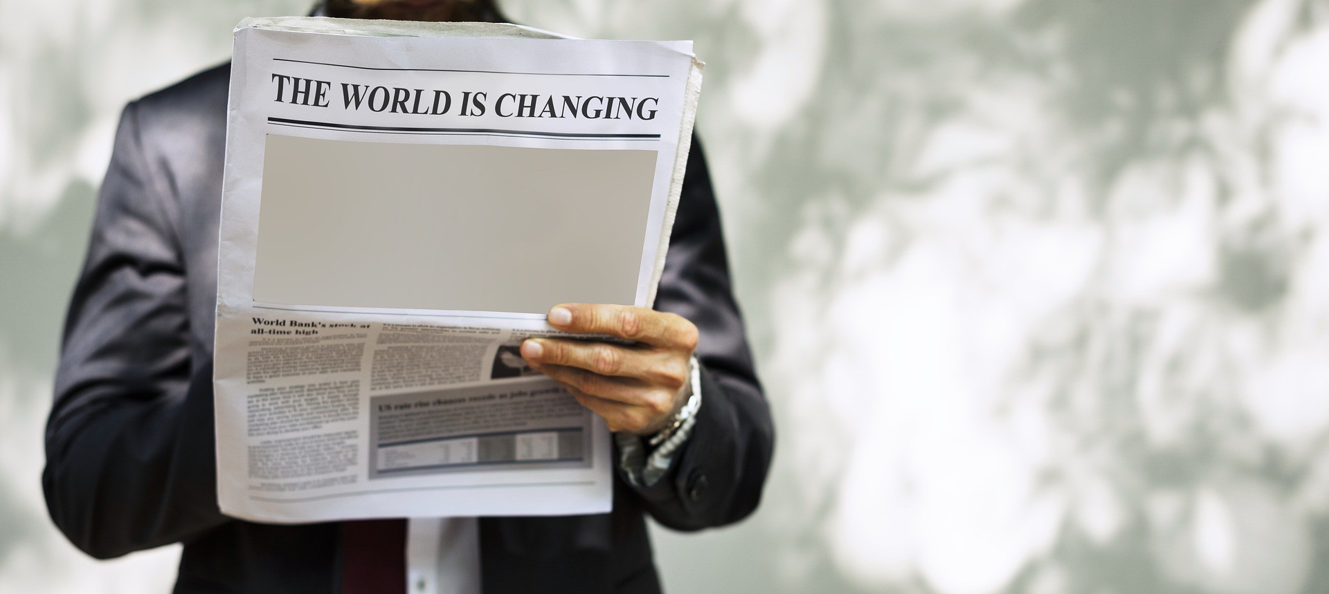 Man reading newspaper with the headline the world is changing