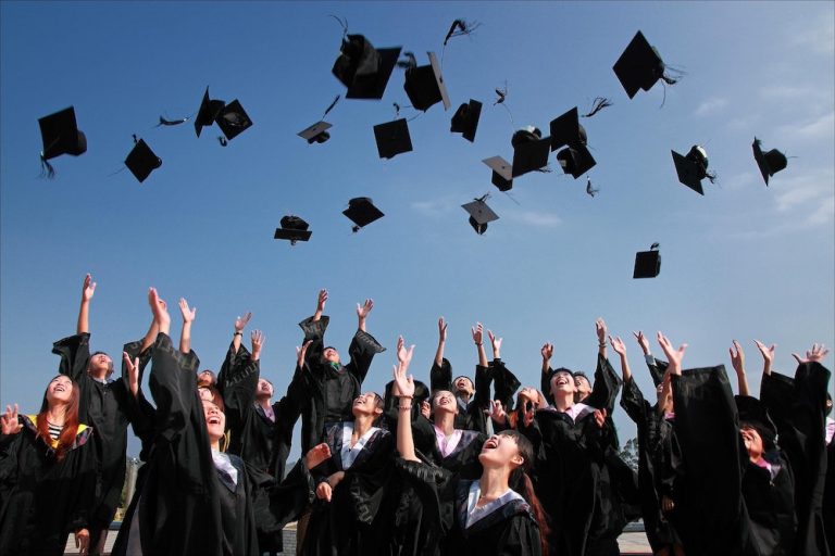 college student tossing hats