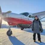 Kelly in front of a plane in alaska