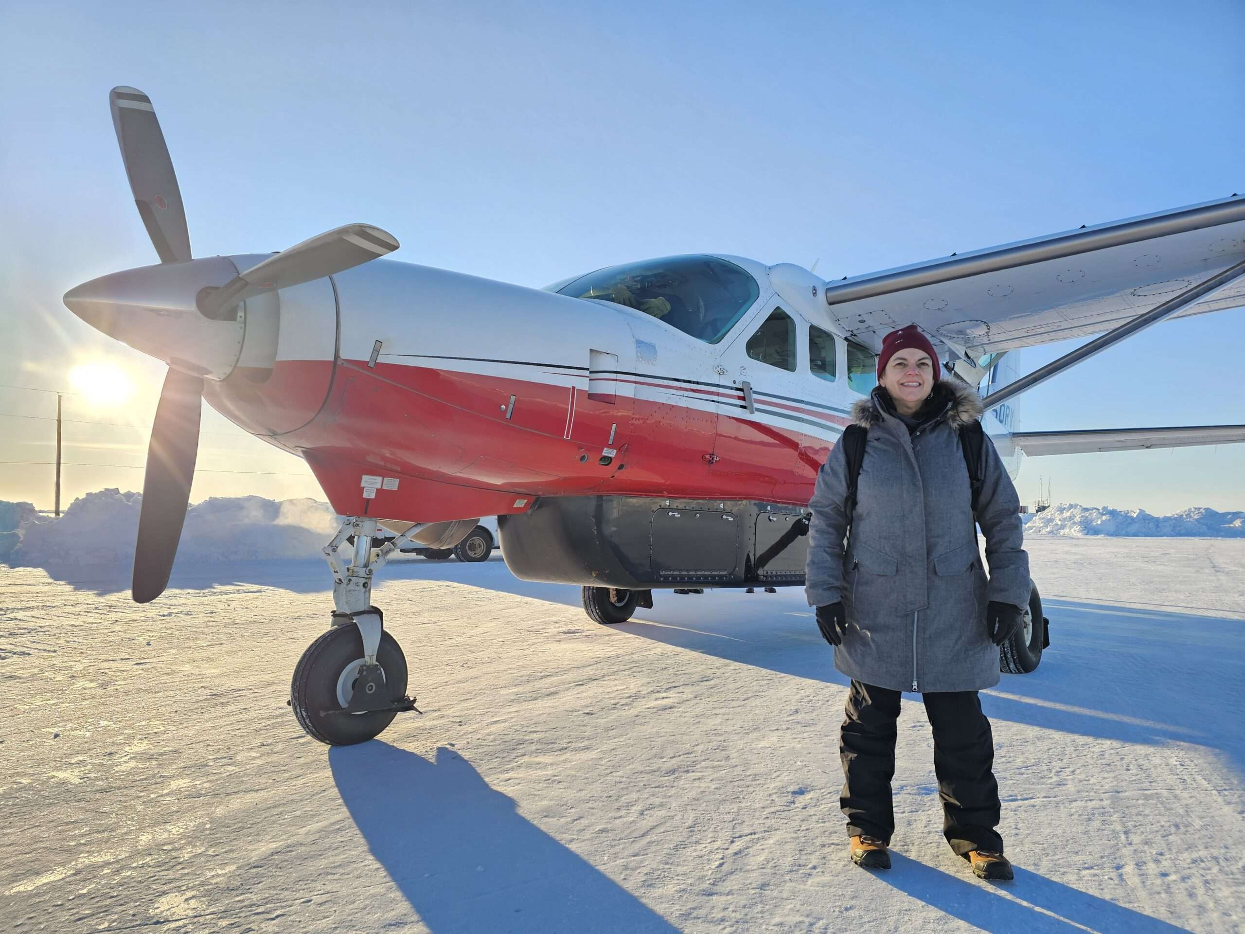 Kelly in front of a plane in alaska
