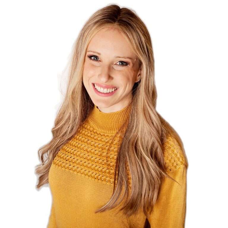Smiling woman with long blonde hair wearing a mustard knit sweater against a white background facing slightly to the left