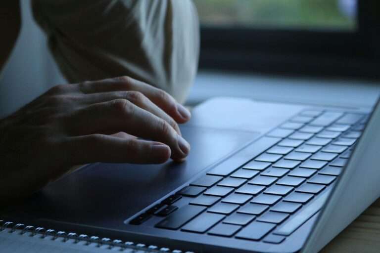 Close up of hands typing on a laptop keyboard on a desk